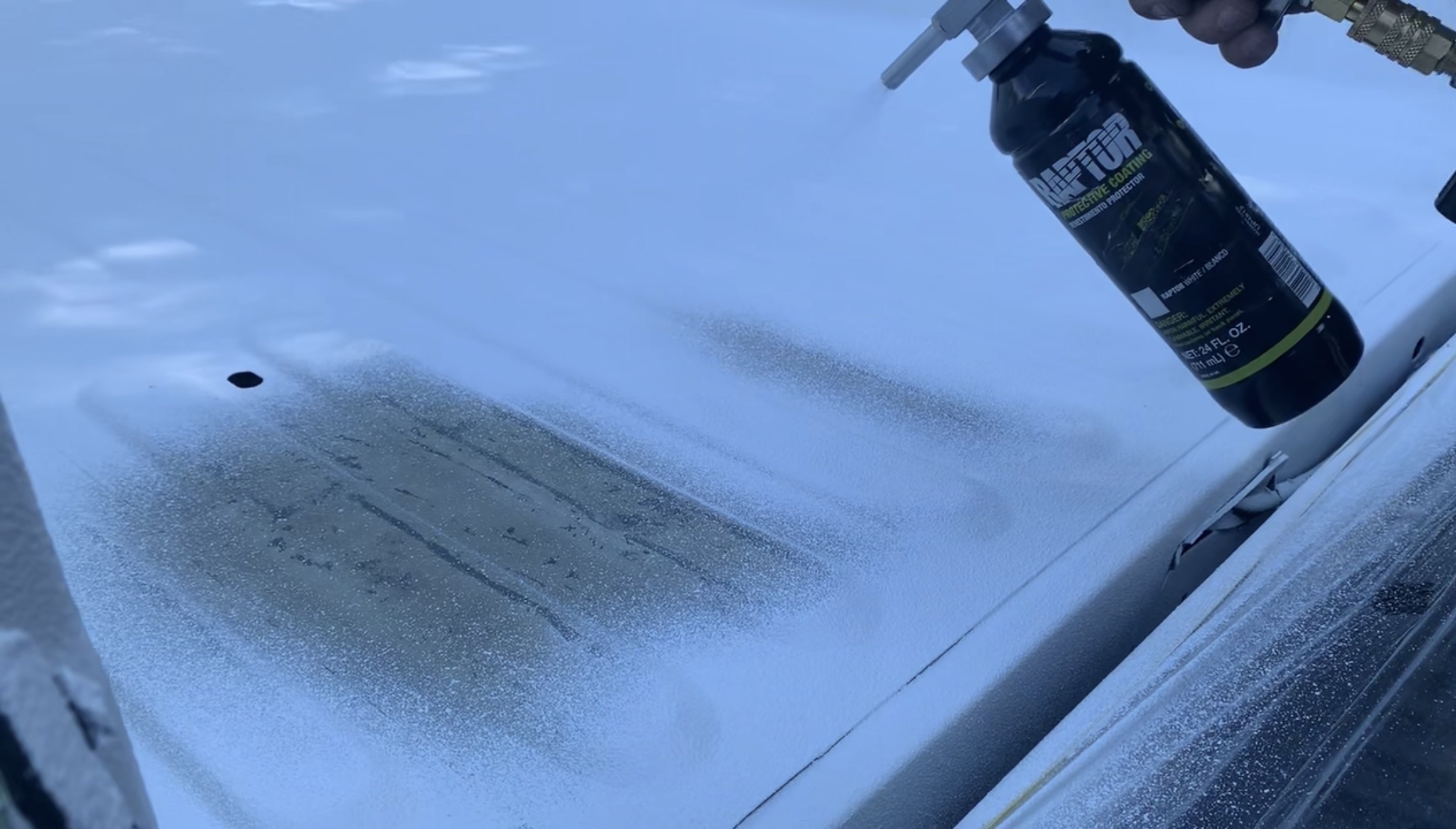 Truck bed being coated with Raptor bedliner by Green Mountain Mobile Sandblasting and Powder Coating