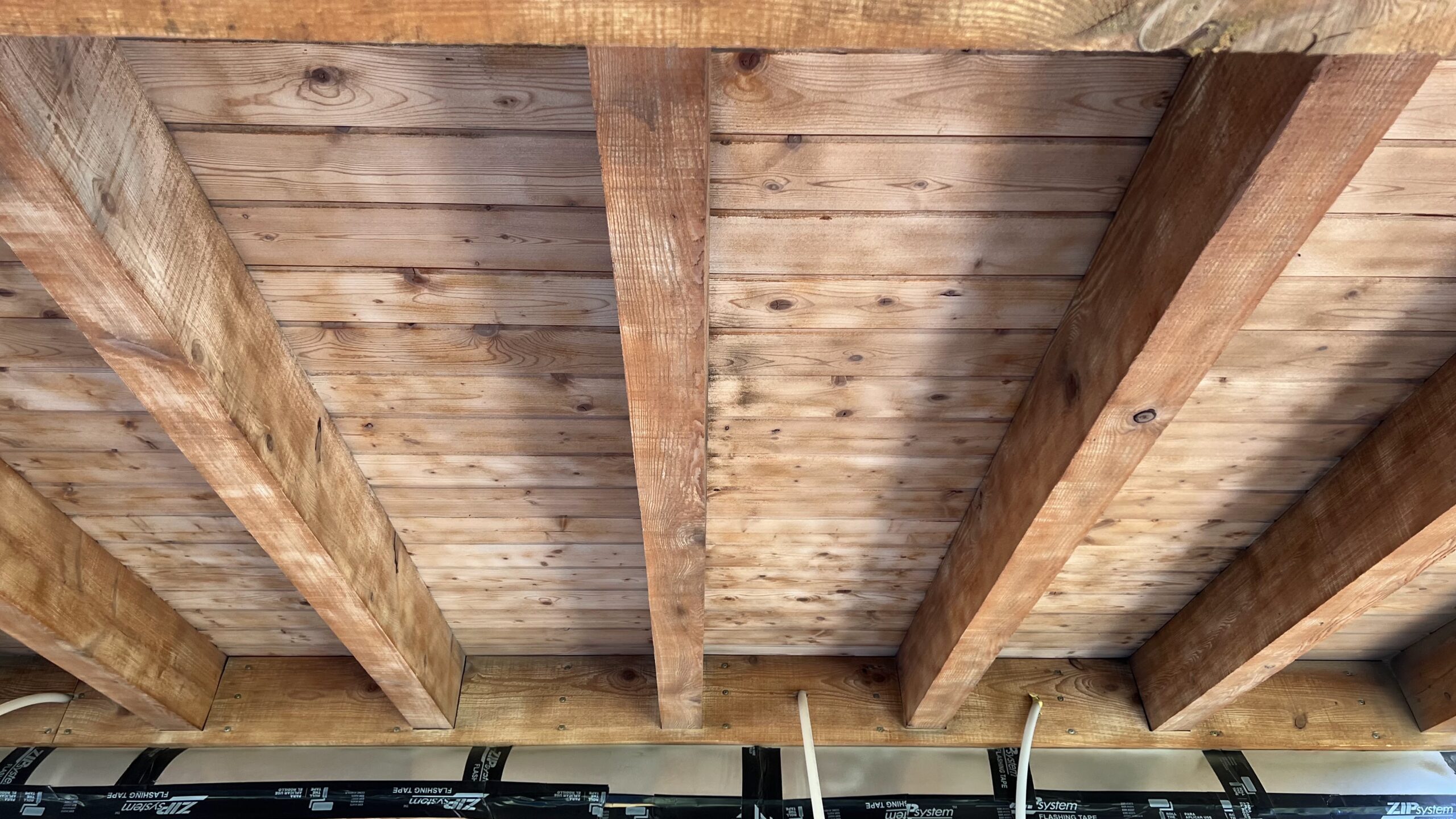 Porch Restoration – Sandblasting Dark Stain Off Wood Surface Wooden porch with dark stain sandblasted and restored by Green Mountain Mobile Sandblasting and Powder Coating