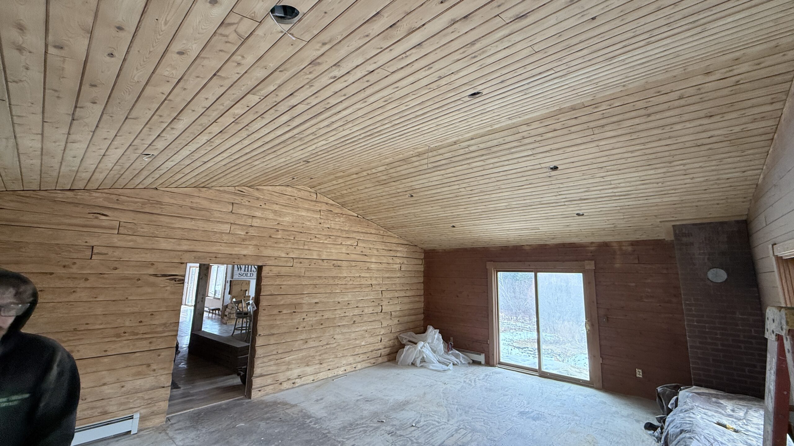 Log Cabin Bedroom Ceiling and Wall Sandblasting Log cabin bedroom ceiling and log wall being sandblasted during renovation by Green Mountain Mobile Sandblasting and Powder Coating LLC
