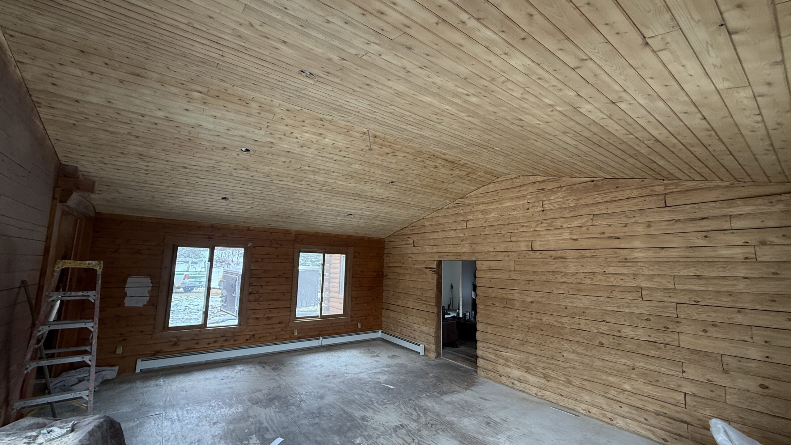 Log Cabin Bedroom Ceiling and Wall Sandblasting Log cabin bedroom ceiling and log wall being sandblasted during renovation by Green Mountain Mobile Sandblasting and Powder Coating LLC
