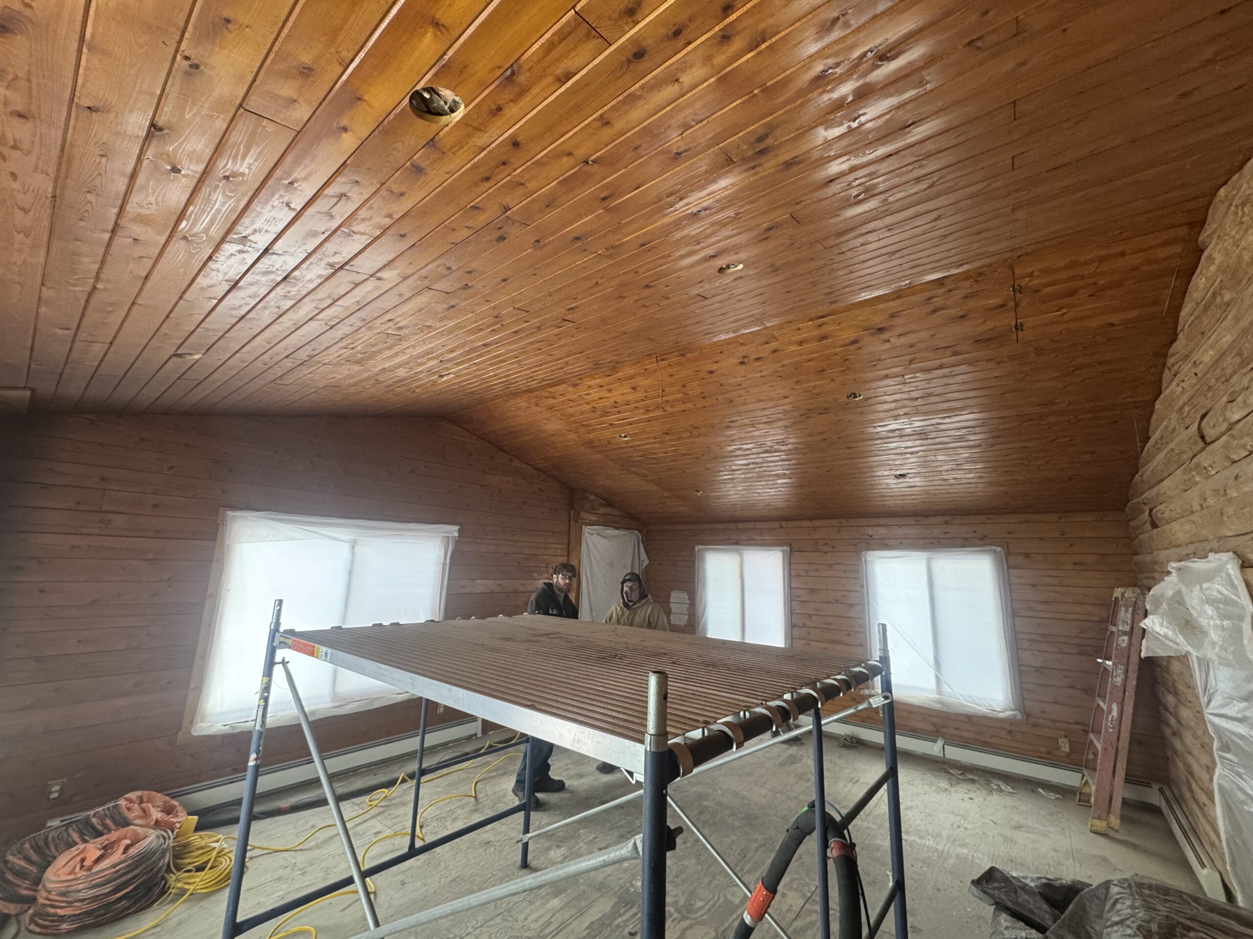 Log Cabin Bedroom Ceiling and Wall Sandblasting Log cabin bedroom ceiling and log wall being sandblasted during renovation by Green Mountain Mobile Sandblasting and Powder Coating LLC
