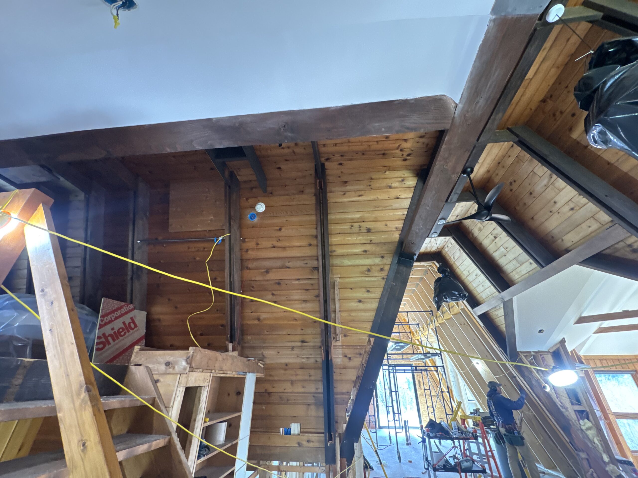 Log Cabin Interior Restoration – Before & After Sandblasting Log cabin interior sandblasting restoration showing dark brown beams and golden brown tongue and groove before and after by Green Mountain Sandblasting and Powder Coating LLC