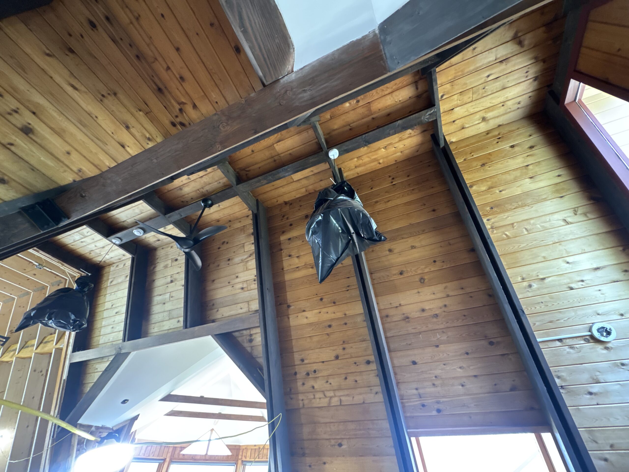 Log Cabin Interior Restoration – Before & After Sandblasting Log cabin interior sandblasting restoration showing dark brown beams and golden brown tongue and groove before and after by Green Mountain Sandblasting and Powder Coating LLC