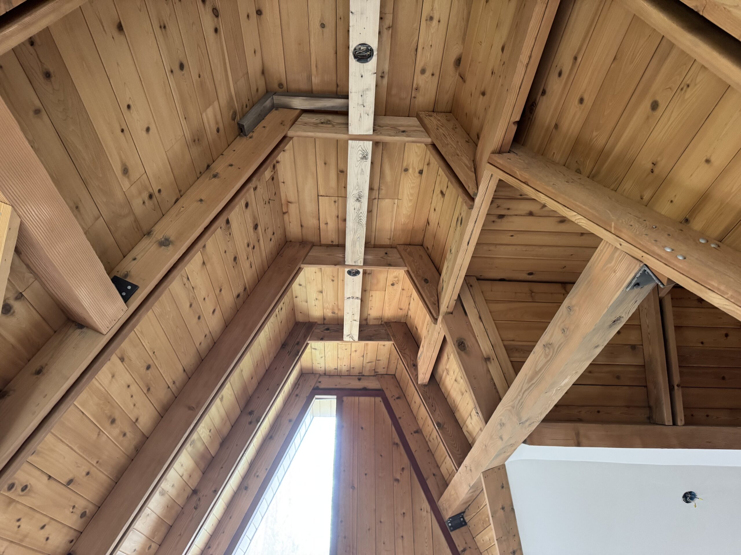 Log Cabin Interior Restoration – Before & After Sandblasting Log cabin interior sandblasting restoration showing dark brown beams and golden brown tongue and groove before and after by Green Mountain Sandblasting and Powder Coating LLC
