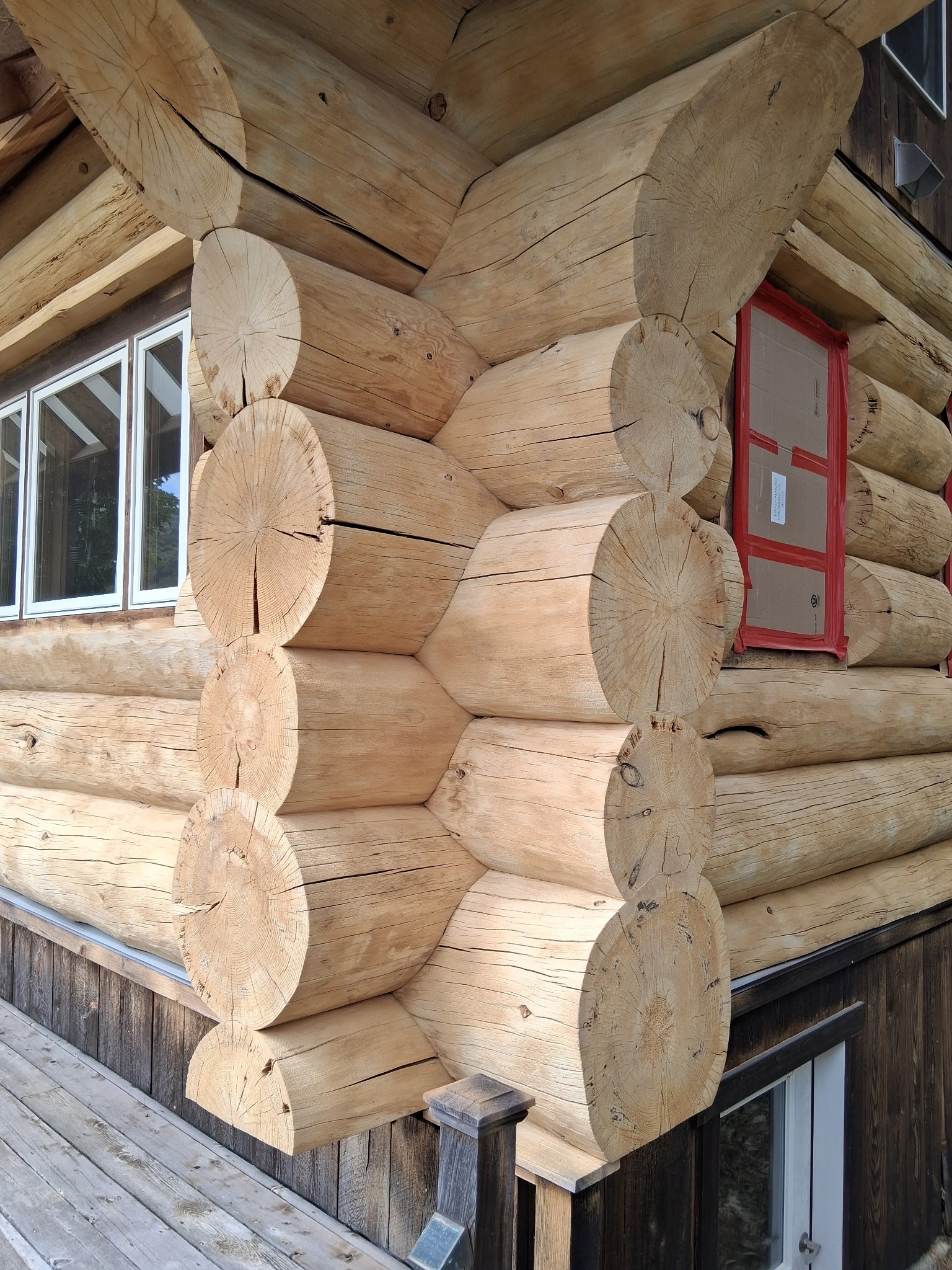 Log Cabin Sandblasting & Weathering Removal – Roxbury, Vermont Before and after log cabin restoration in Roxbury Vermont showing gray weathered logs sandblasted back to clean natural wood