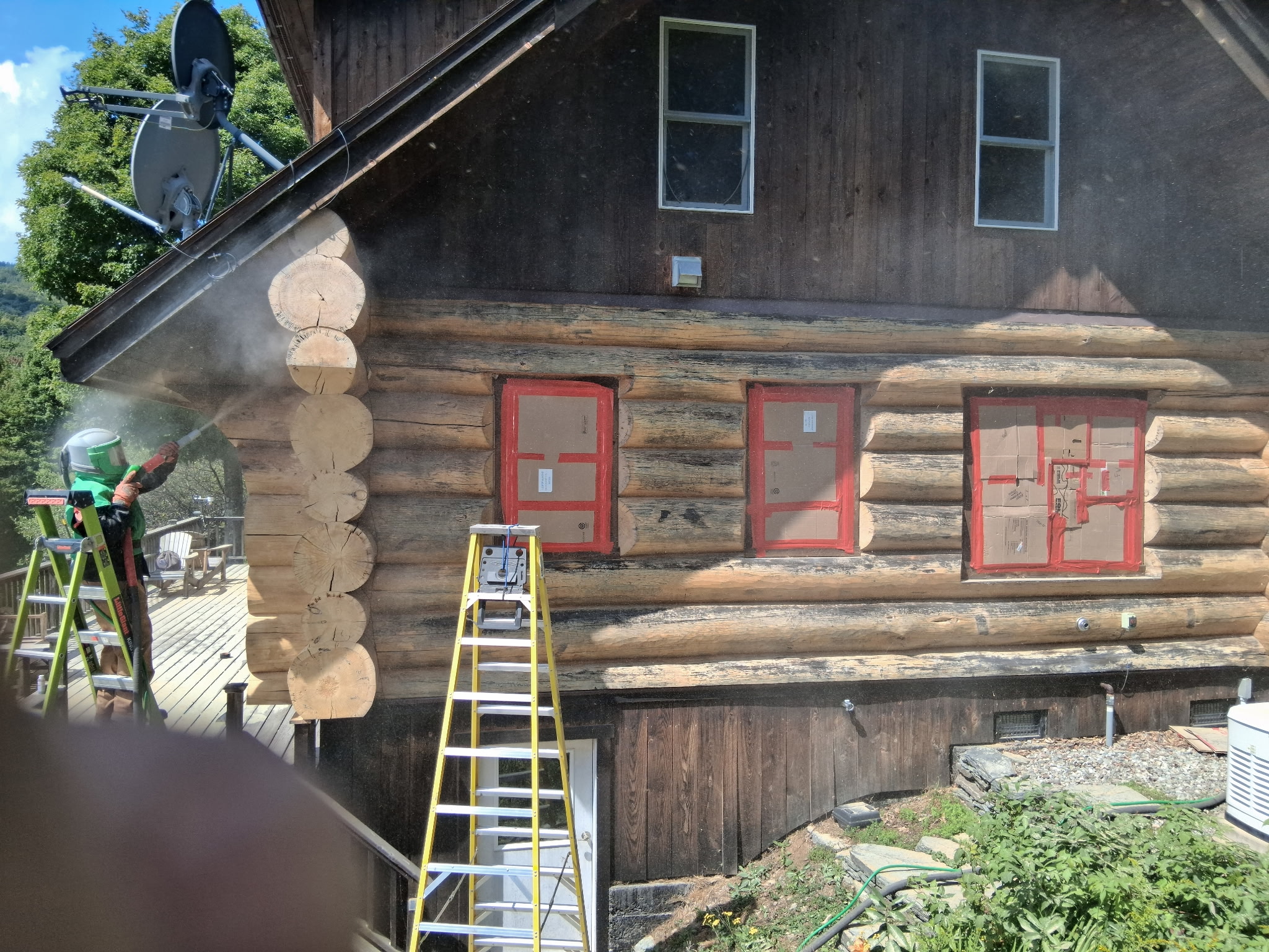 Log Cabin Sandblasting & Weathering Removal – Roxbury, Vermont Before and after log cabin restoration in Roxbury Vermont showing gray weathered logs sandblasted back to clean natural wood