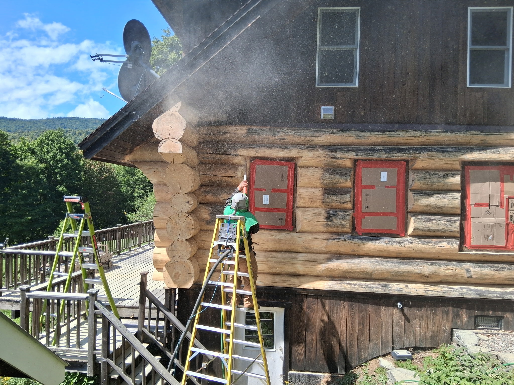 Log Cabin Sandblasting & Weathering Removal – Roxbury, Vermont Before and after log cabin restoration in Roxbury Vermont showing gray weathered logs sandblasted back to clean natural wood