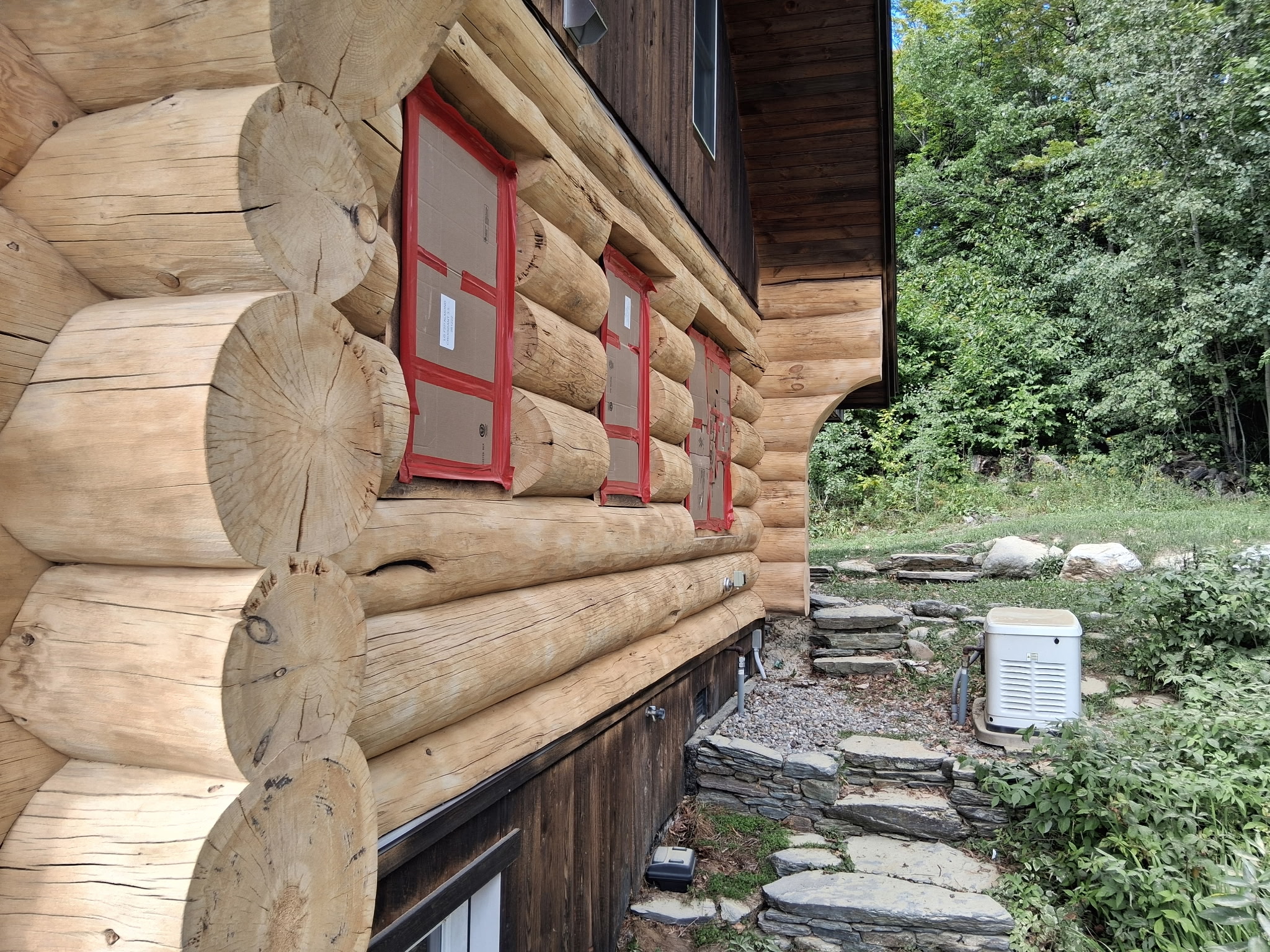 Log Cabin Sandblasting & Weathering Removal – Roxbury, Vermont Before and after log cabin restoration in Roxbury Vermont showing gray weathered logs sandblasted back to clean natural wood