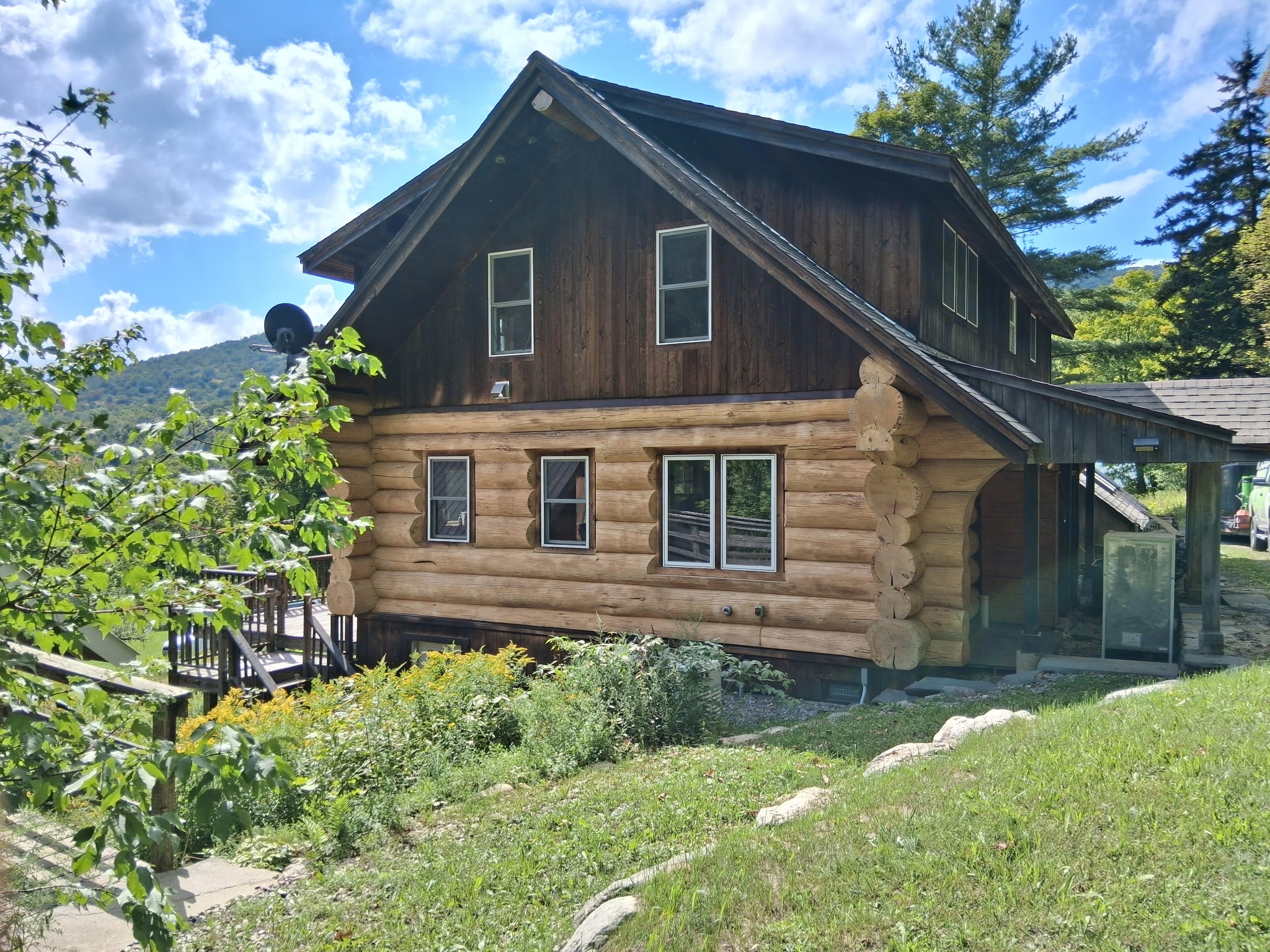Log Cabin Sandblasting & Weathering Removal – Roxbury, Vermont Before and after log cabin restoration in Roxbury Vermont showing gray weathered logs sandblasted back to clean natural wood