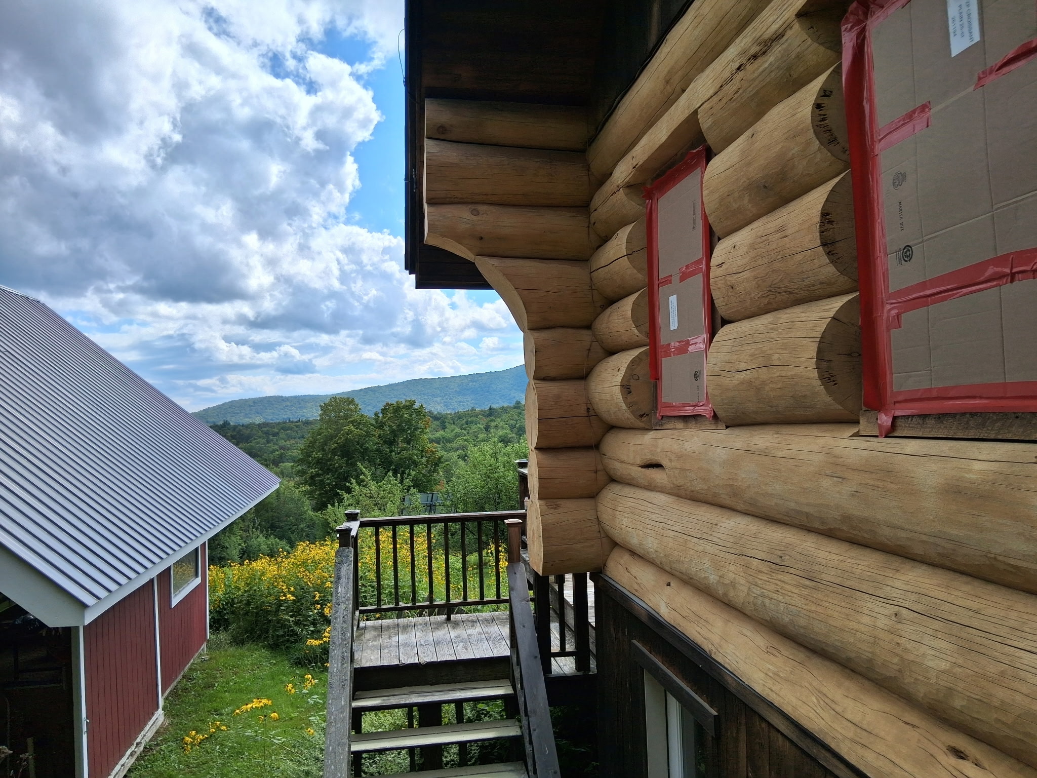 Log Cabin Sandblasting & Weathering Removal – Roxbury, Vermont Before and after log cabin restoration in Roxbury Vermont showing gray weathered logs sandblasted back to clean natural wood