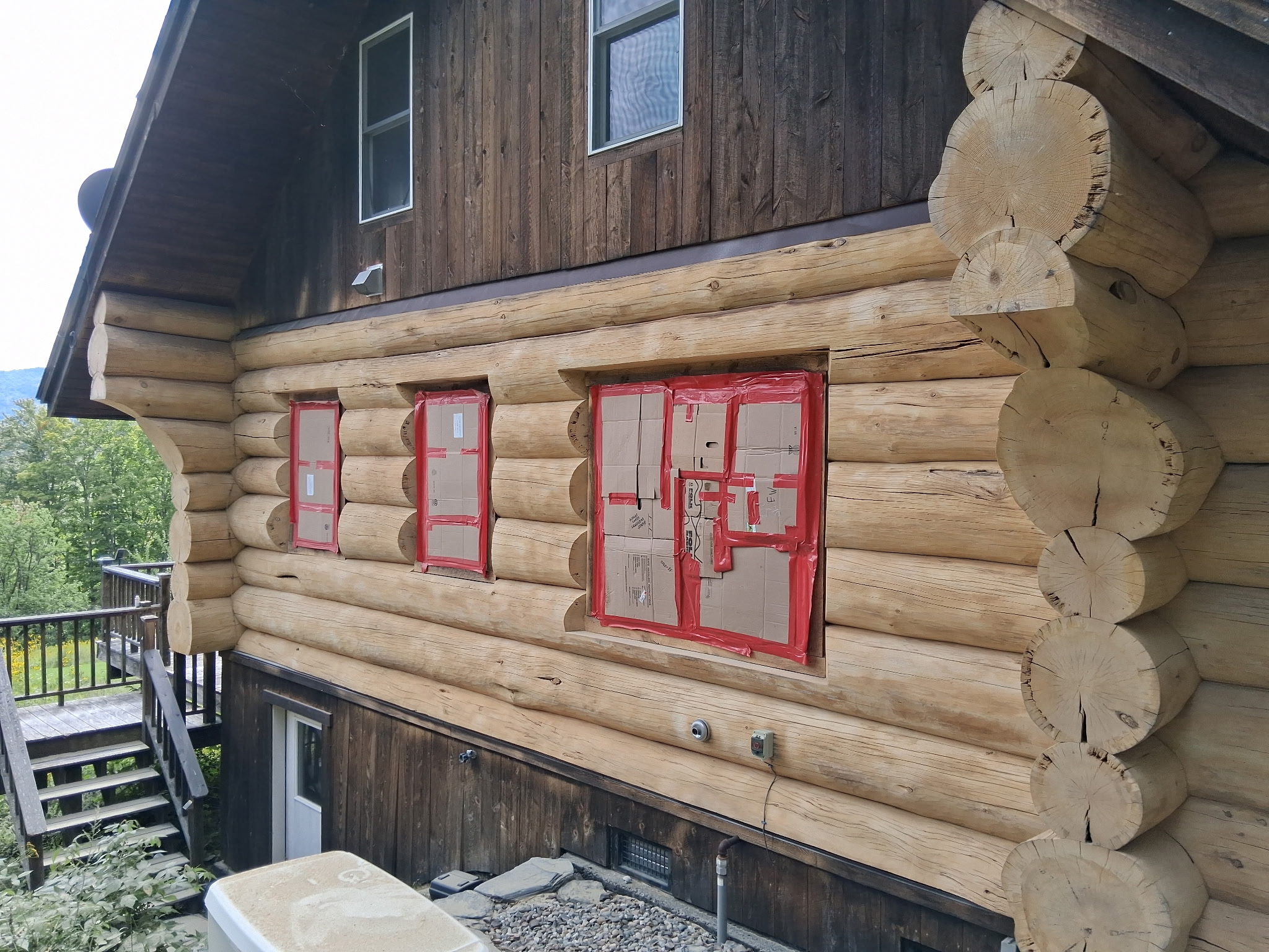 Log Cabin Sandblasting & Weathering Removal – Roxbury, Vermont Before and after log cabin restoration in Roxbury Vermont showing gray weathered logs sandblasted back to clean natural wood