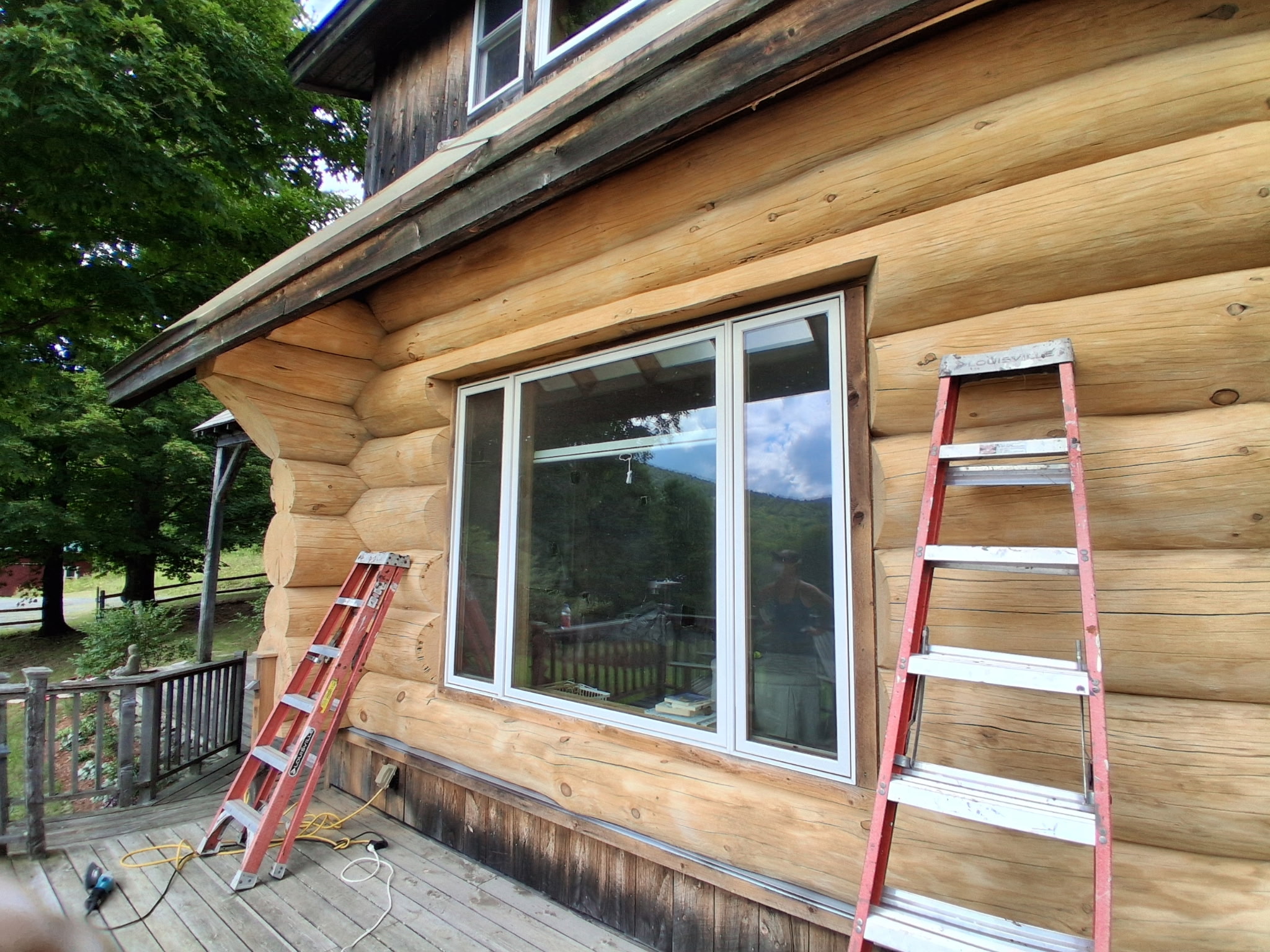 Log Cabin Sandblasting & Weathering Removal – Roxbury, Vermont Before and after log cabin restoration in Roxbury Vermont showing gray weathered logs sandblasted back to clean natural wood