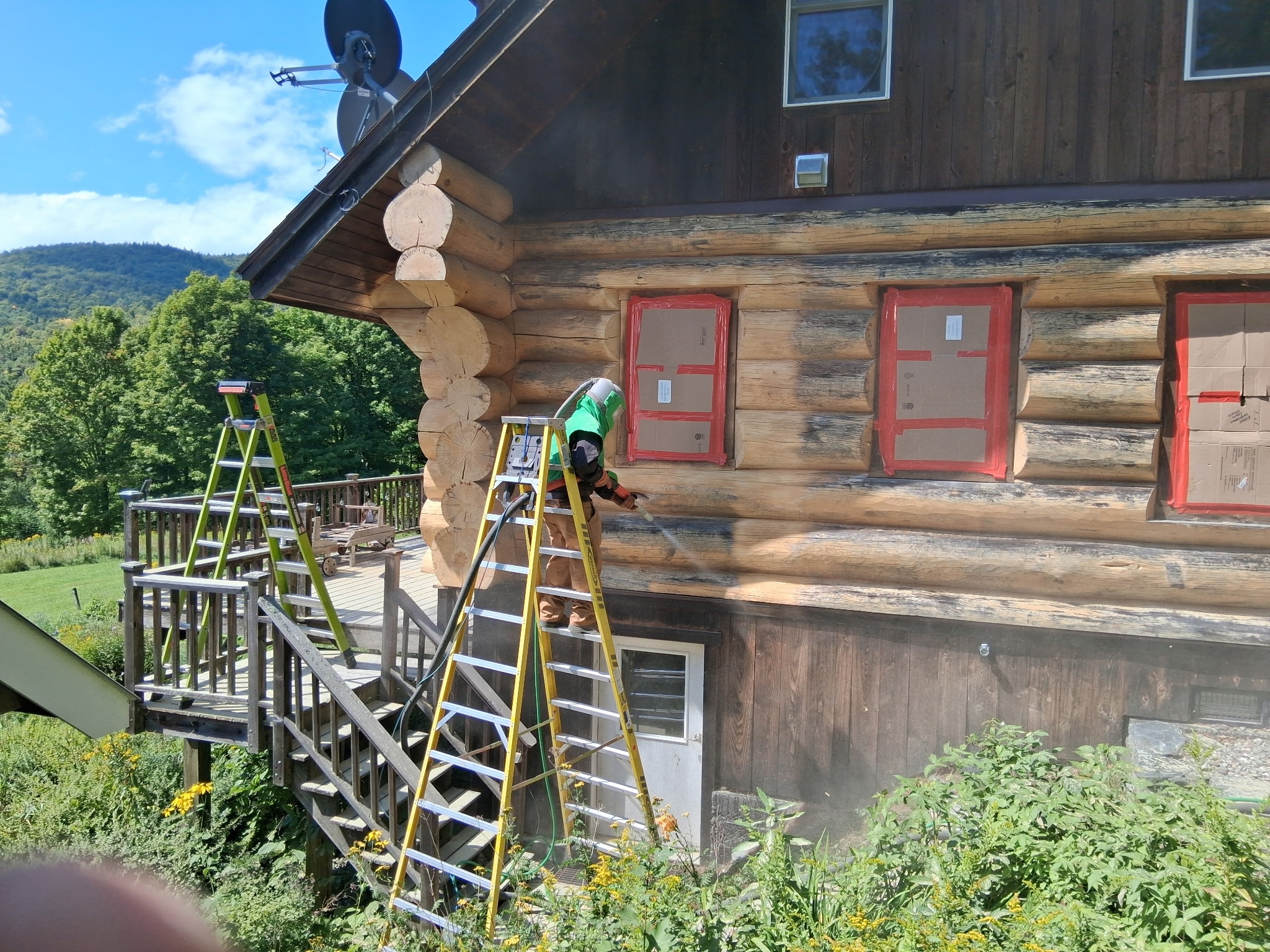 Log Cabin Sandblasting & Weathering Removal – Roxbury, Vermont Before and after log cabin restoration in Roxbury Vermont showing gray weathered logs sandblasted back to clean natural wood