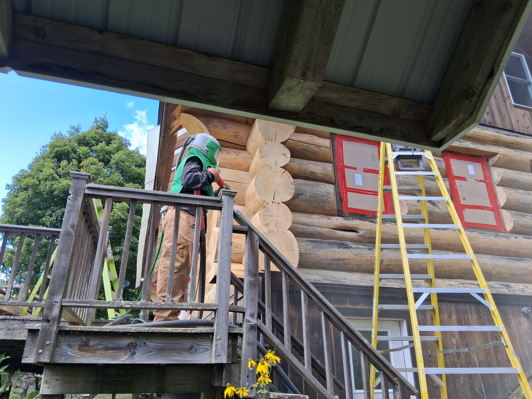 Log Cabin Sandblasting & Weathering Removal – Roxbury, Vermont Before and after log cabin restoration in Roxbury Vermont showing gray weathered logs sandblasted back to clean natural wood