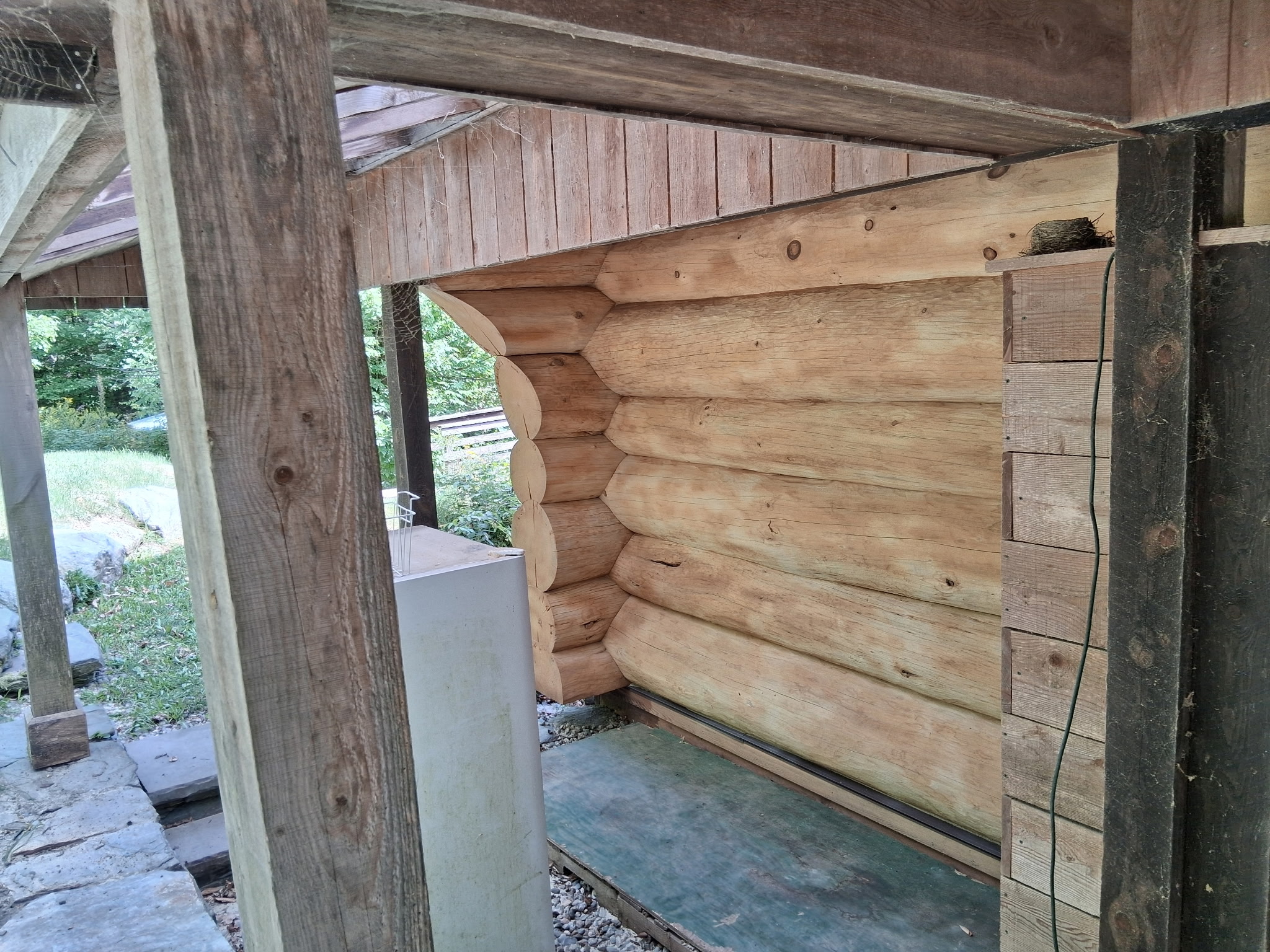 Log Cabin Sandblasting & Weathering Removal – Roxbury, Vermont Before and after log cabin restoration in Roxbury Vermont showing gray weathered logs sandblasted back to clean natural wood
