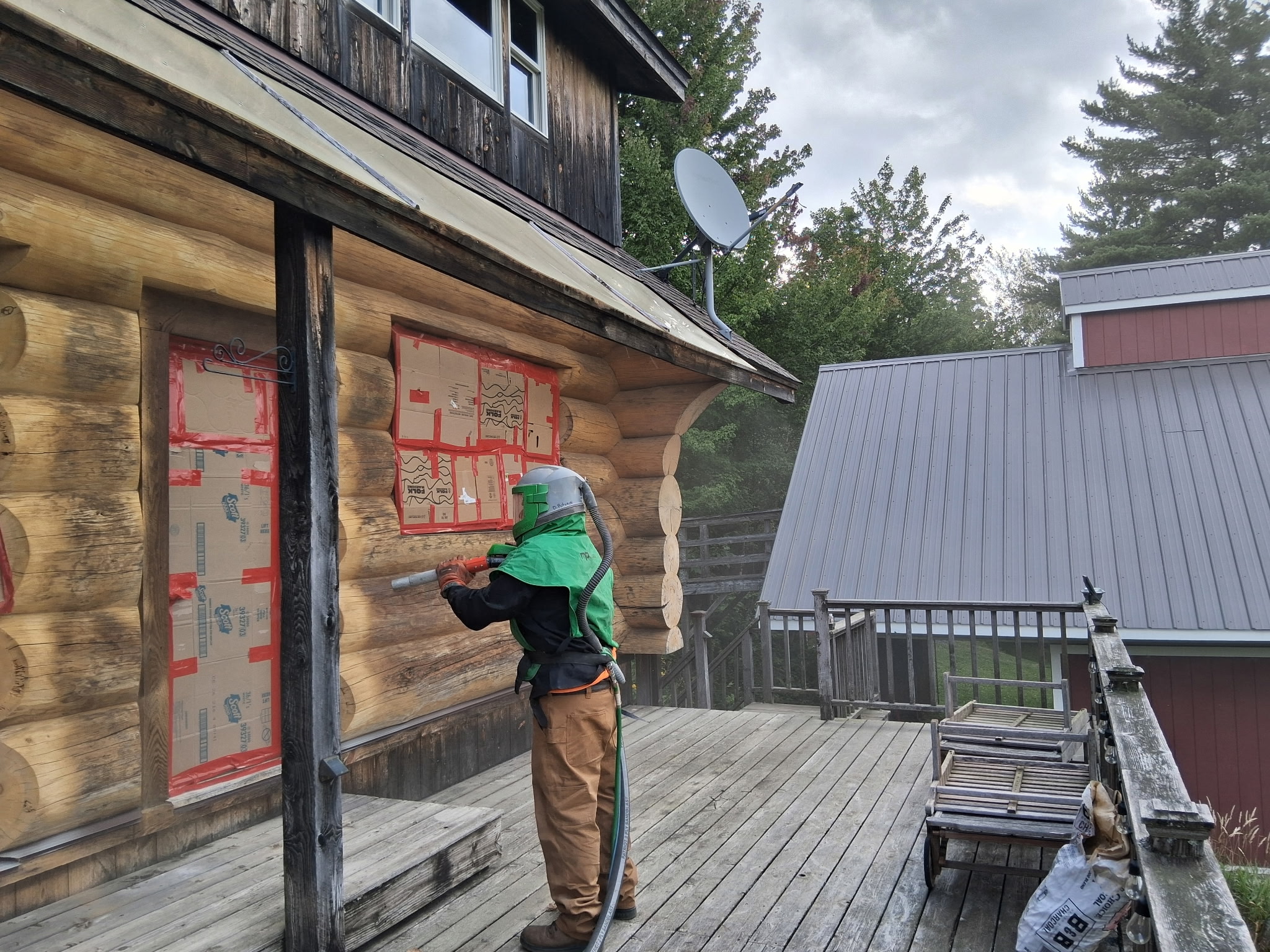 Log Cabin Sandblasting & Weathering Removal – Roxbury, Vermont Before and after log cabin restoration in Roxbury Vermont showing gray weathered logs sandblasted back to clean natural wood