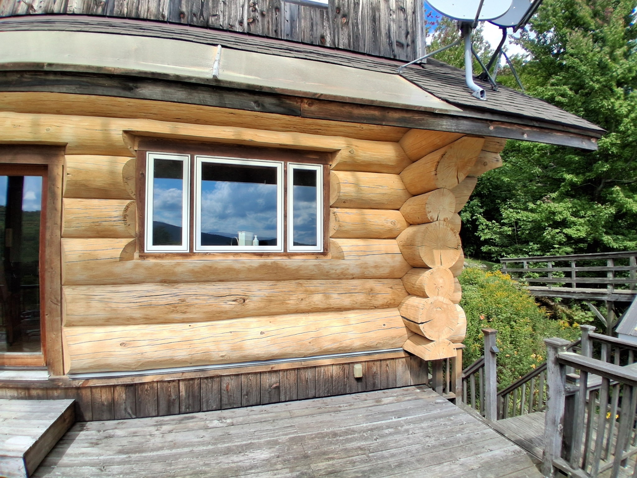 Log Cabin Sandblasting & Weathering Removal – Roxbury, Vermont Before and after log cabin restoration in Roxbury Vermont showing gray weathered logs sandblasted back to clean natural wood