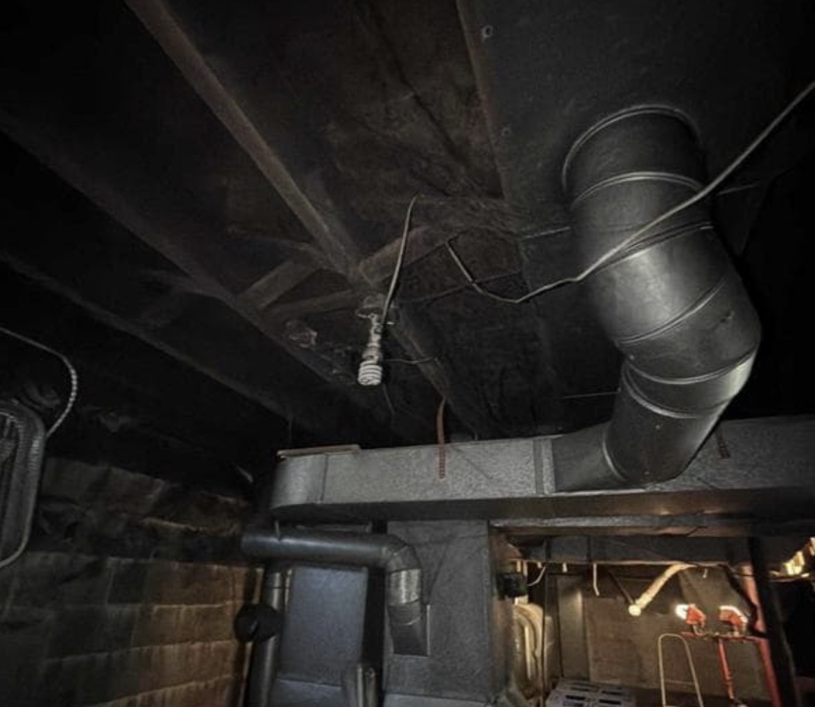 Fire Damage Sandblasting – Bristol, Vermont Before and after fire damage restoration in Bristol Vermont showing sandblasted wood floor joists and concrete basement walls