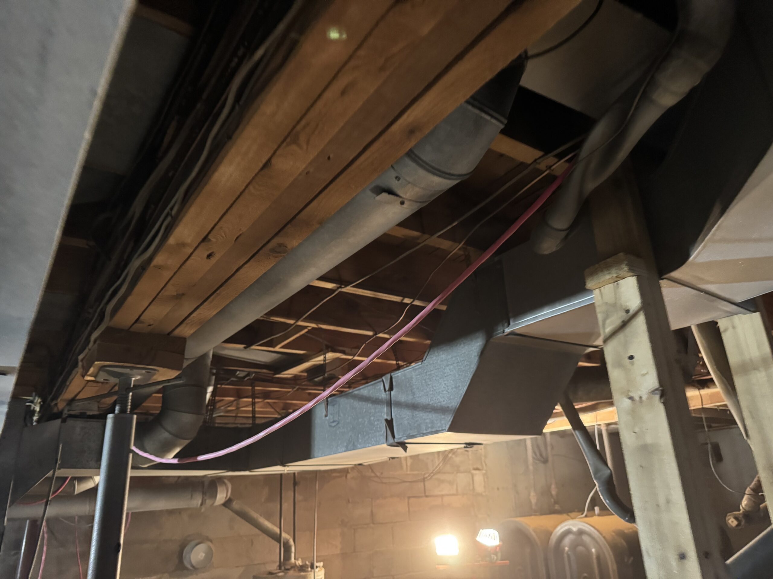 Fire Damage Sandblasting – Bristol, Vermont Before and after fire damage restoration in Bristol Vermont showing sandblasted wood floor joists and concrete basement walls