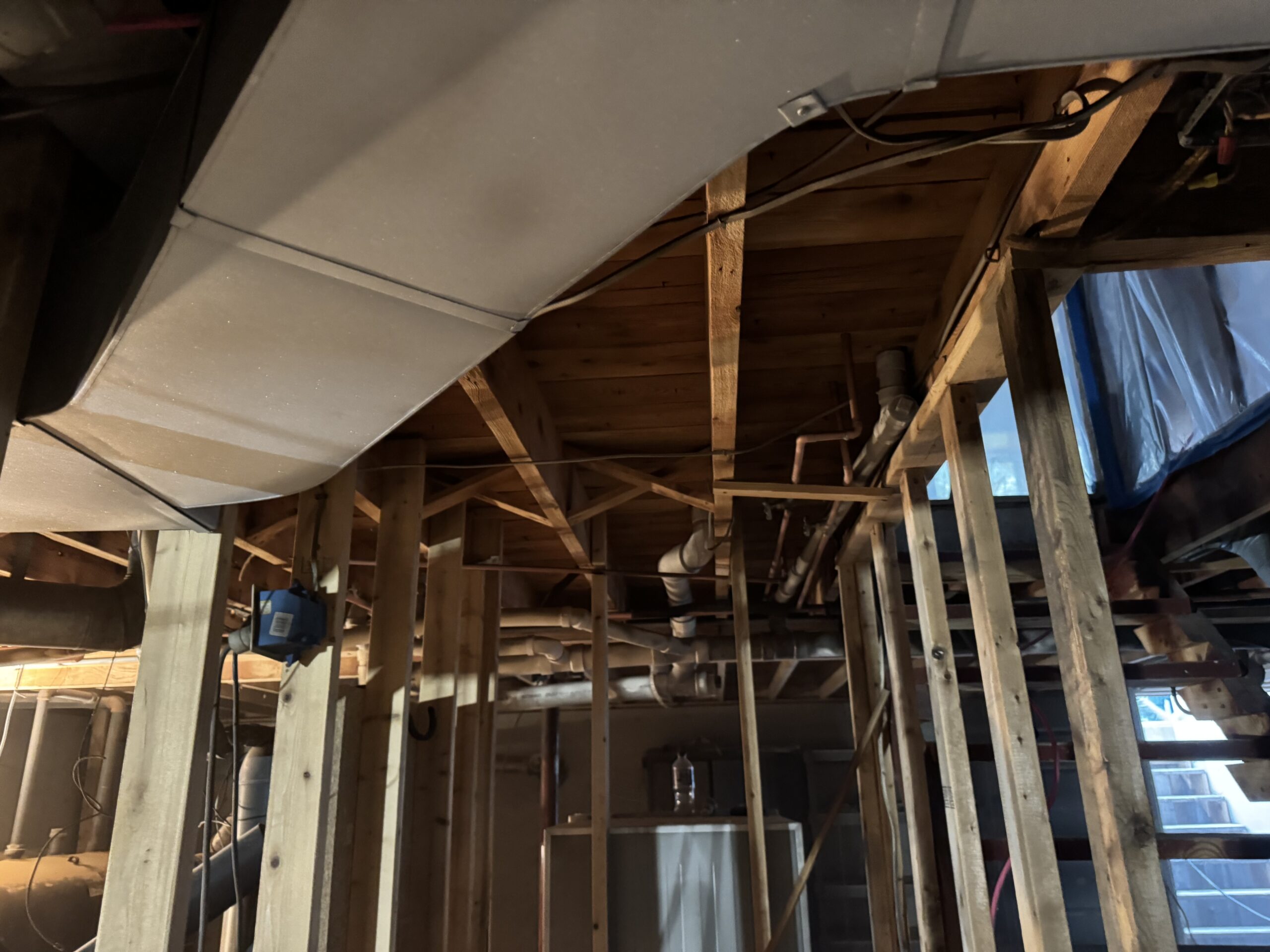 Fire Damage Sandblasting – Bristol, Vermont Before and after fire damage restoration in Bristol Vermont showing sandblasted wood floor joists and concrete basement walls