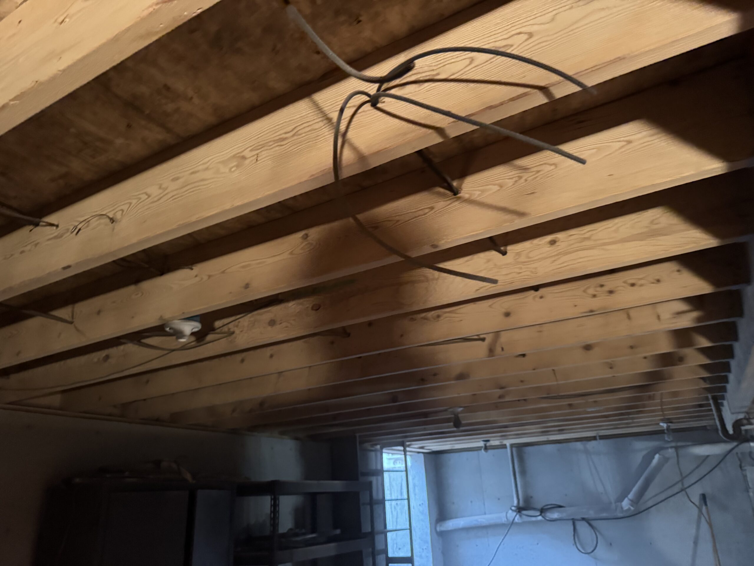 Fire Damage Sandblasting – Bristol, Vermont Before and after fire damage restoration in Bristol Vermont showing sandblasted wood floor joists and concrete basement walls