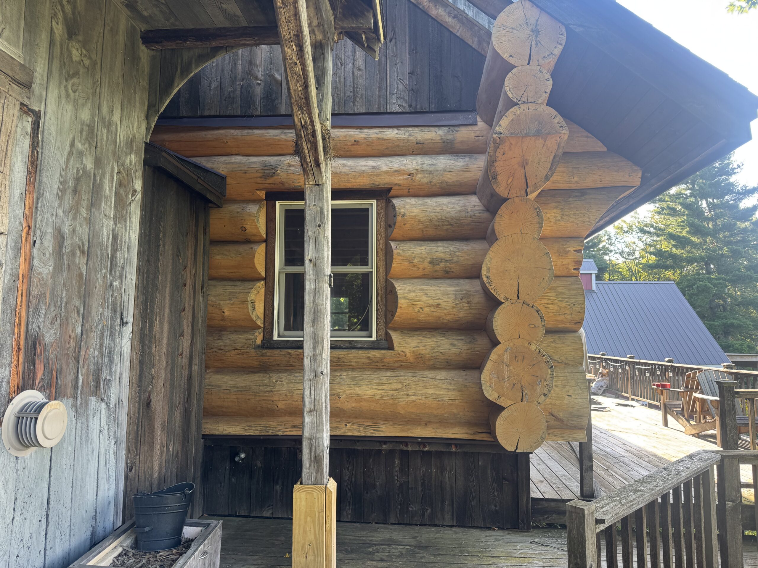 Log Cabin Sandblasting & Weathering Removal – Roxbury, Vermont Before and after log cabin restoration in Roxbury Vermont showing gray weathered logs sandblasted back to clean natural wood