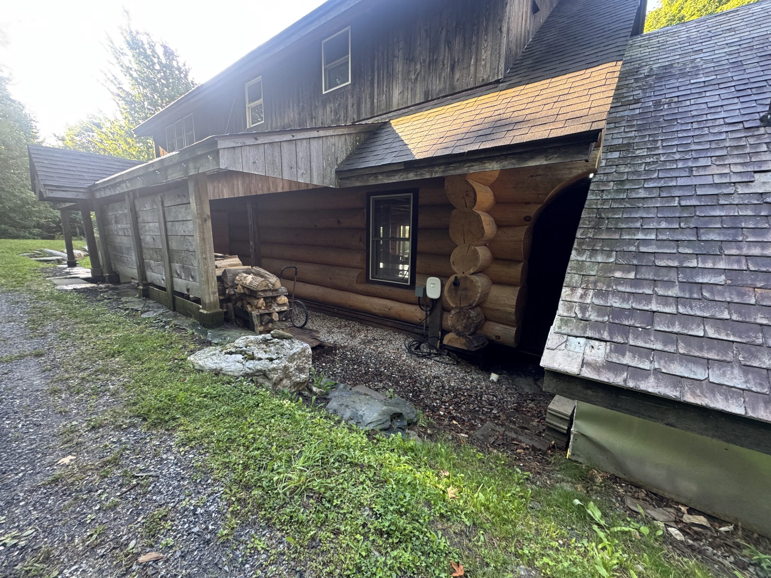 Log Cabin Sandblasting & Weathering Removal – Roxbury, Vermont Before and after log cabin restoration in Roxbury Vermont showing gray weathered logs sandblasted back to clean natural wood