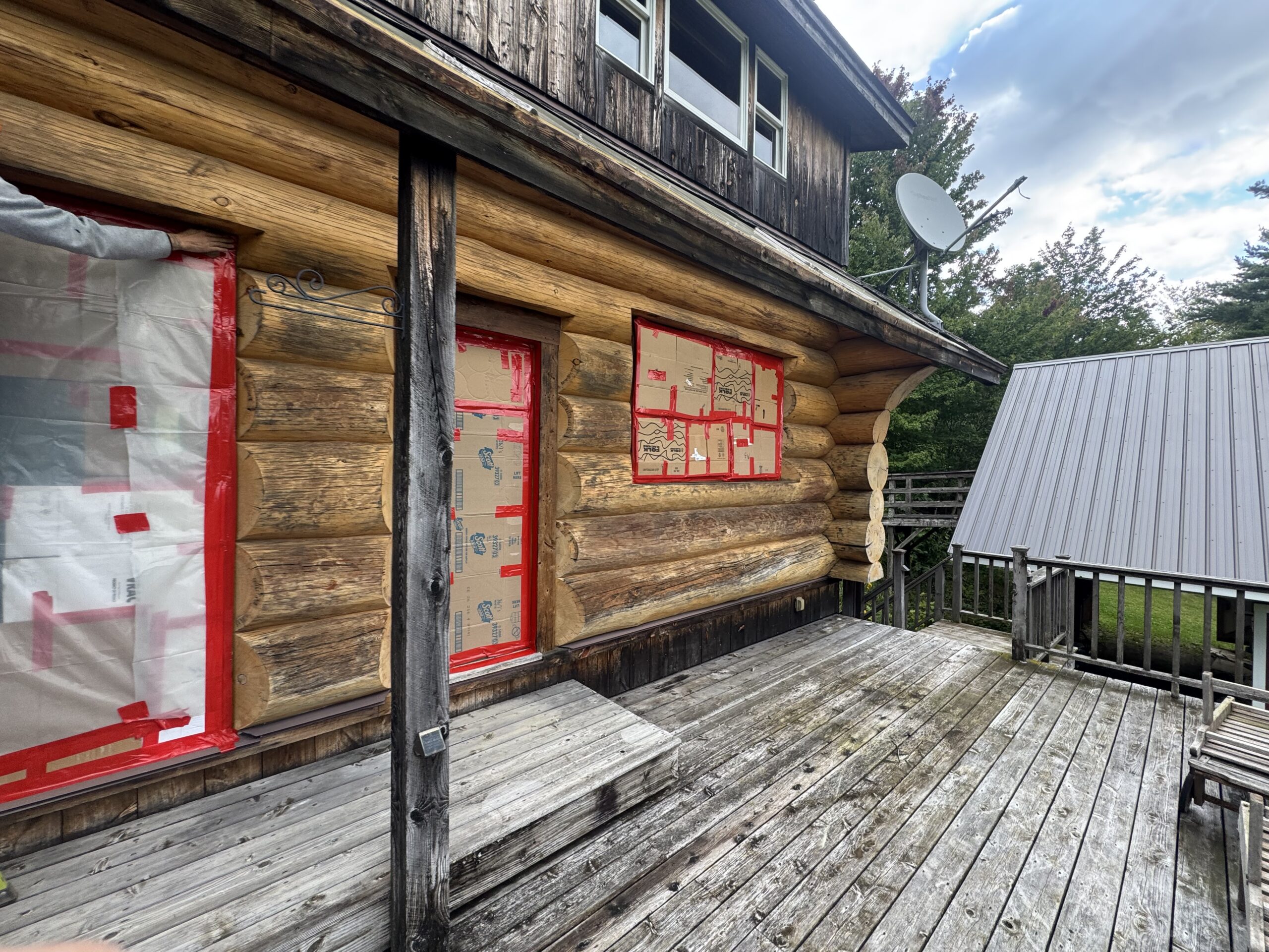 Log Cabin Sandblasting & Weathering Removal – Roxbury, Vermont Before and after log cabin restoration in Roxbury Vermont showing gray weathered logs sandblasted back to clean natural wood