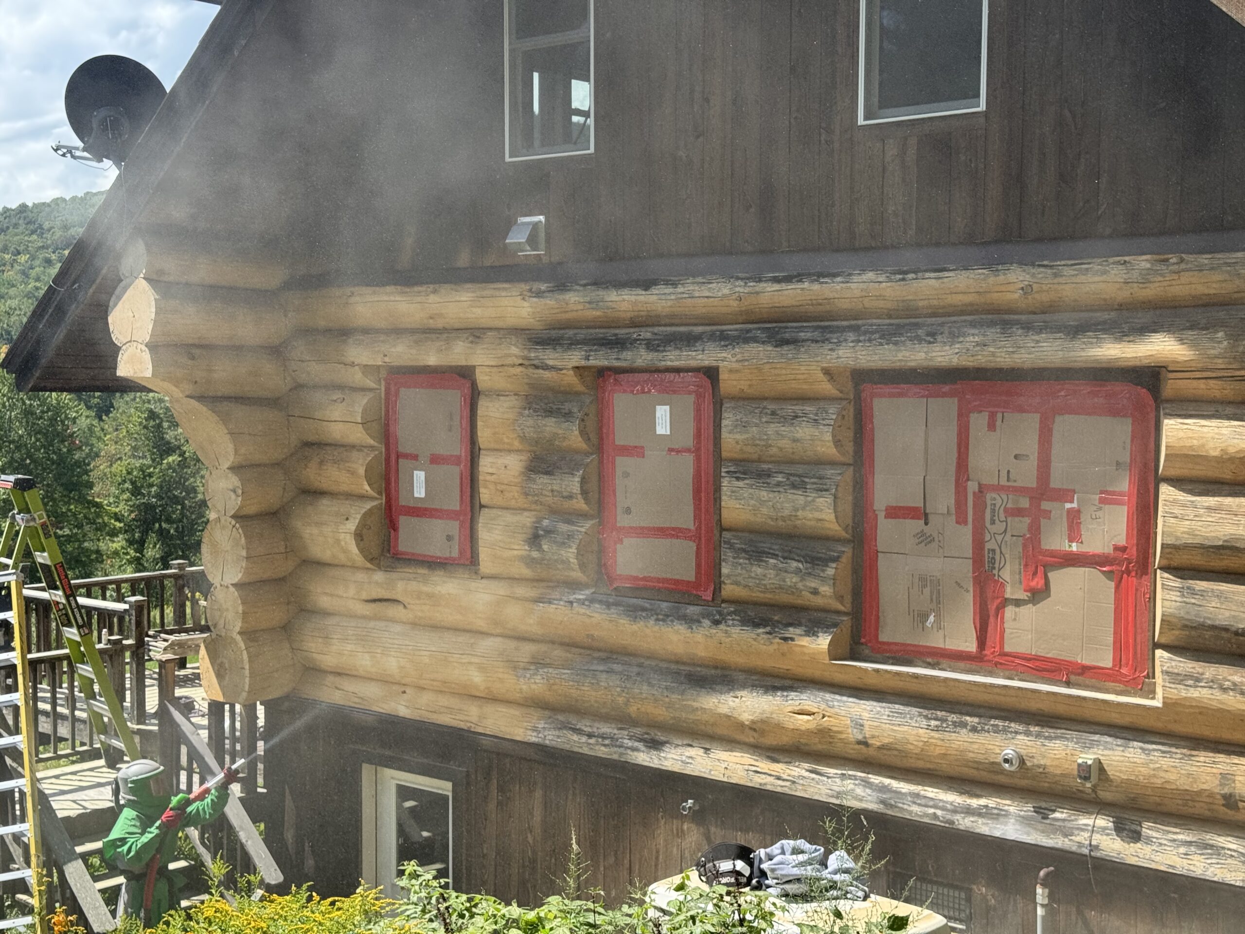 Log Cabin Sandblasting & Weathering Removal – Roxbury, Vermont Before and after log cabin restoration in Roxbury Vermont showing gray weathered logs sandblasted back to clean natural wood