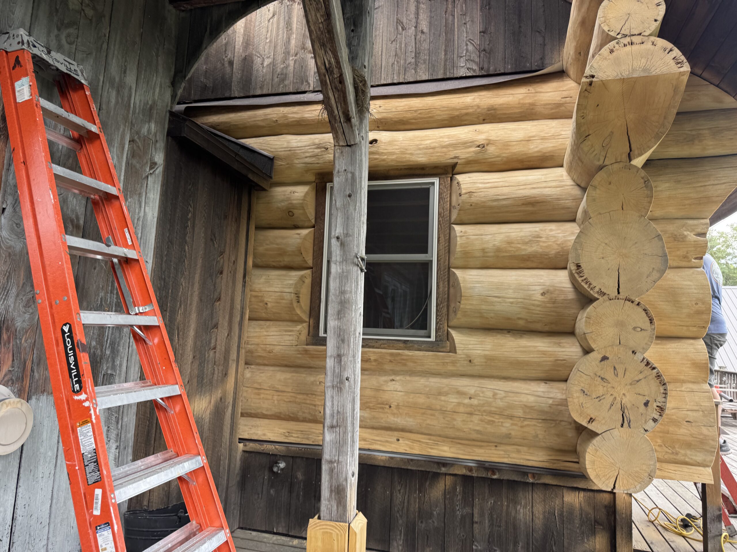 Log Cabin Sandblasting & Weathering Removal – Roxbury, Vermont Before and after log cabin restoration in Roxbury Vermont showing gray weathered logs sandblasted back to clean natural wood
