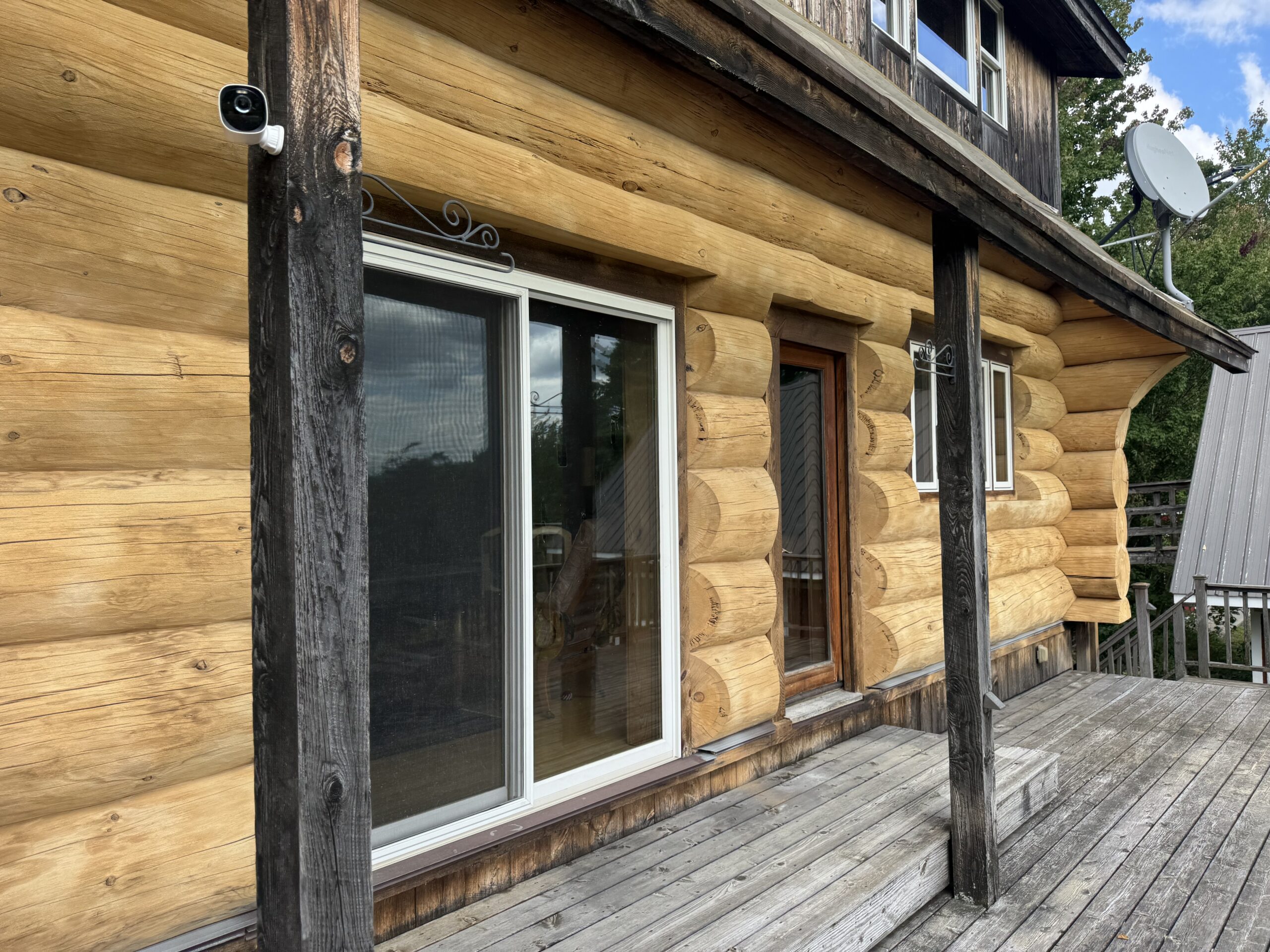 Log Cabin Sandblasting & Weathering Removal – Roxbury, Vermont Before and after log cabin restoration in Roxbury Vermont showing gray weathered logs sandblasted back to clean natural wood
